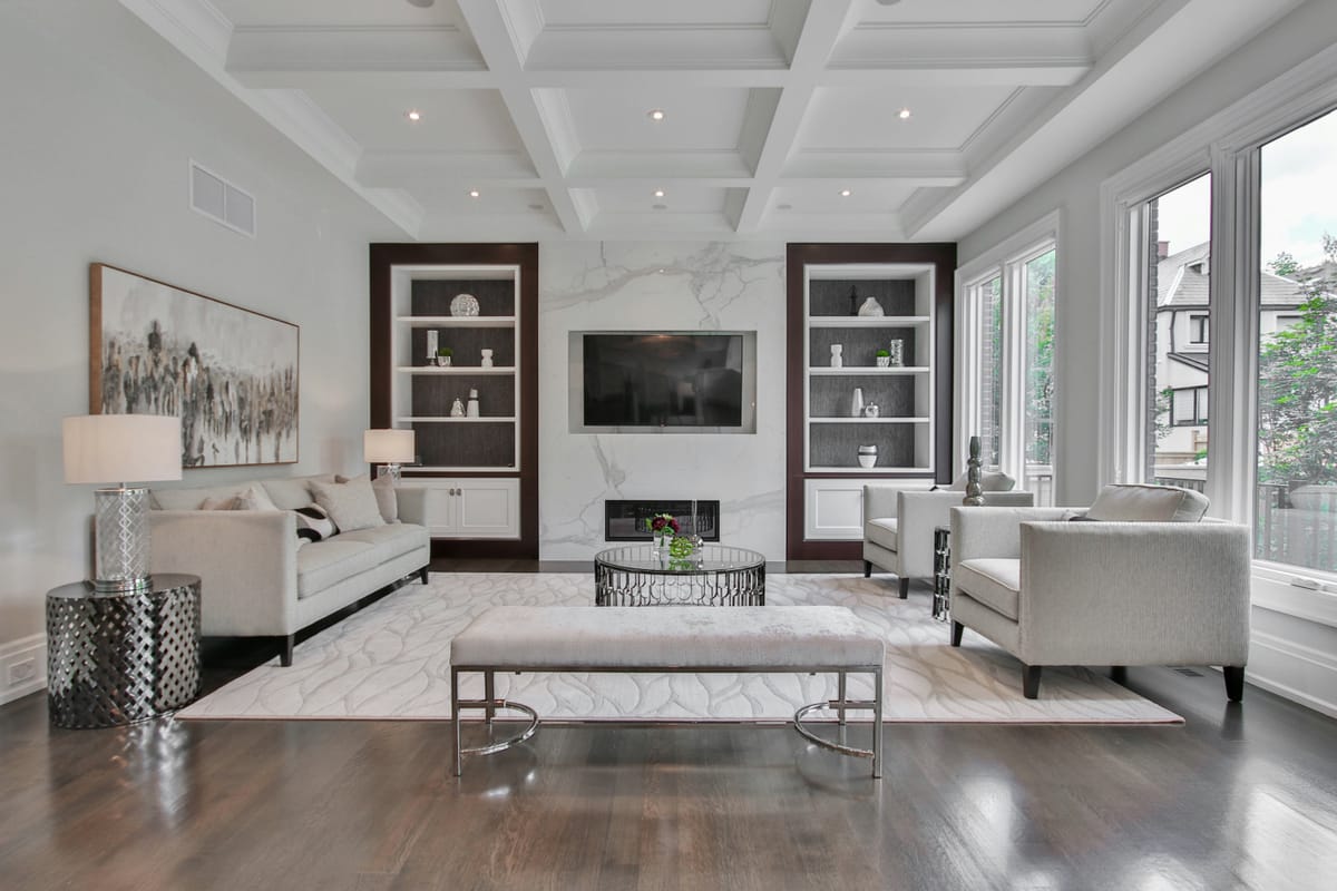 A living room with a wall-mounted TV, lamps and recessed ceiling lights